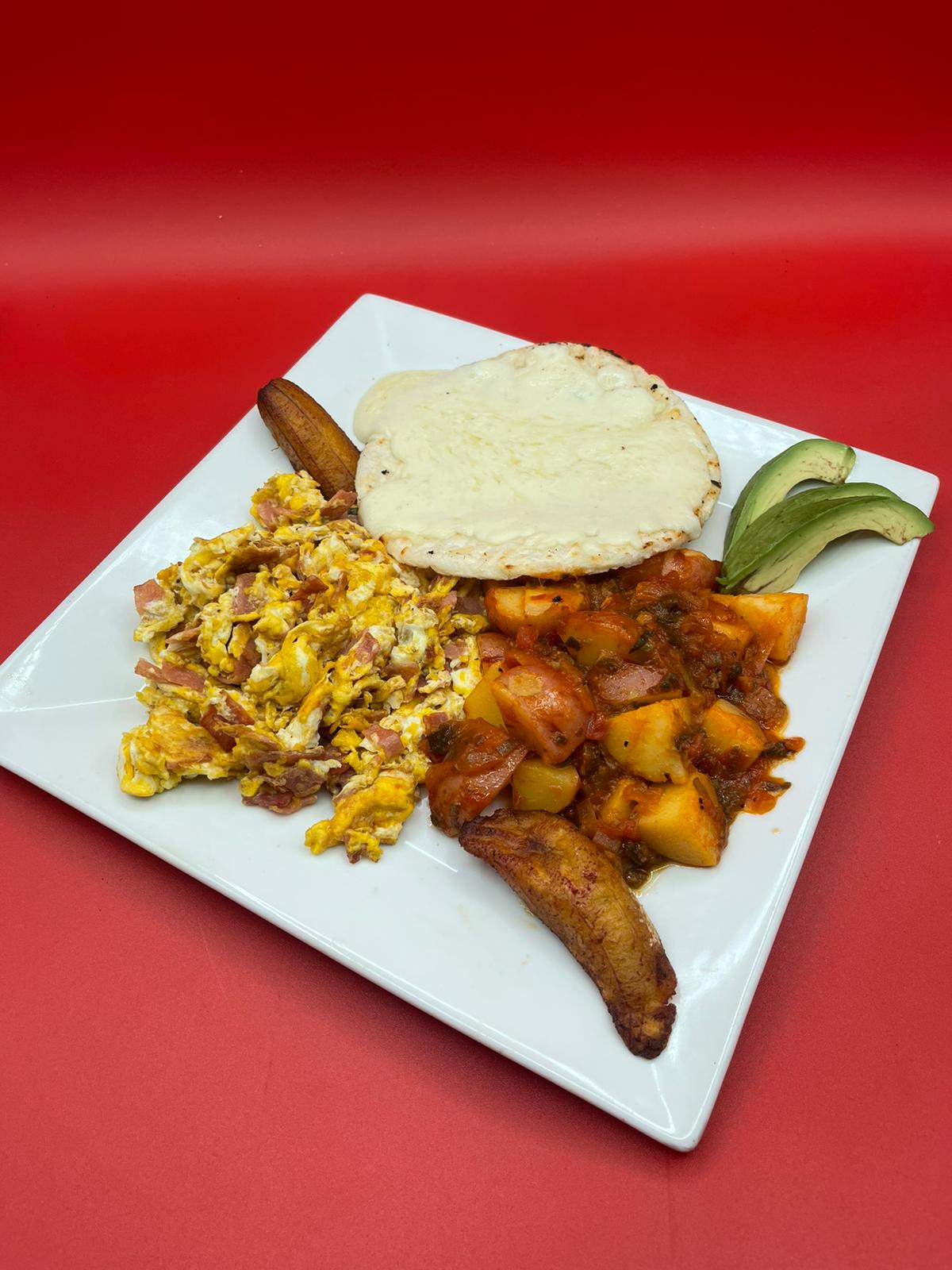 A plate of food with eggs, potatoes and tortillas on a red background.