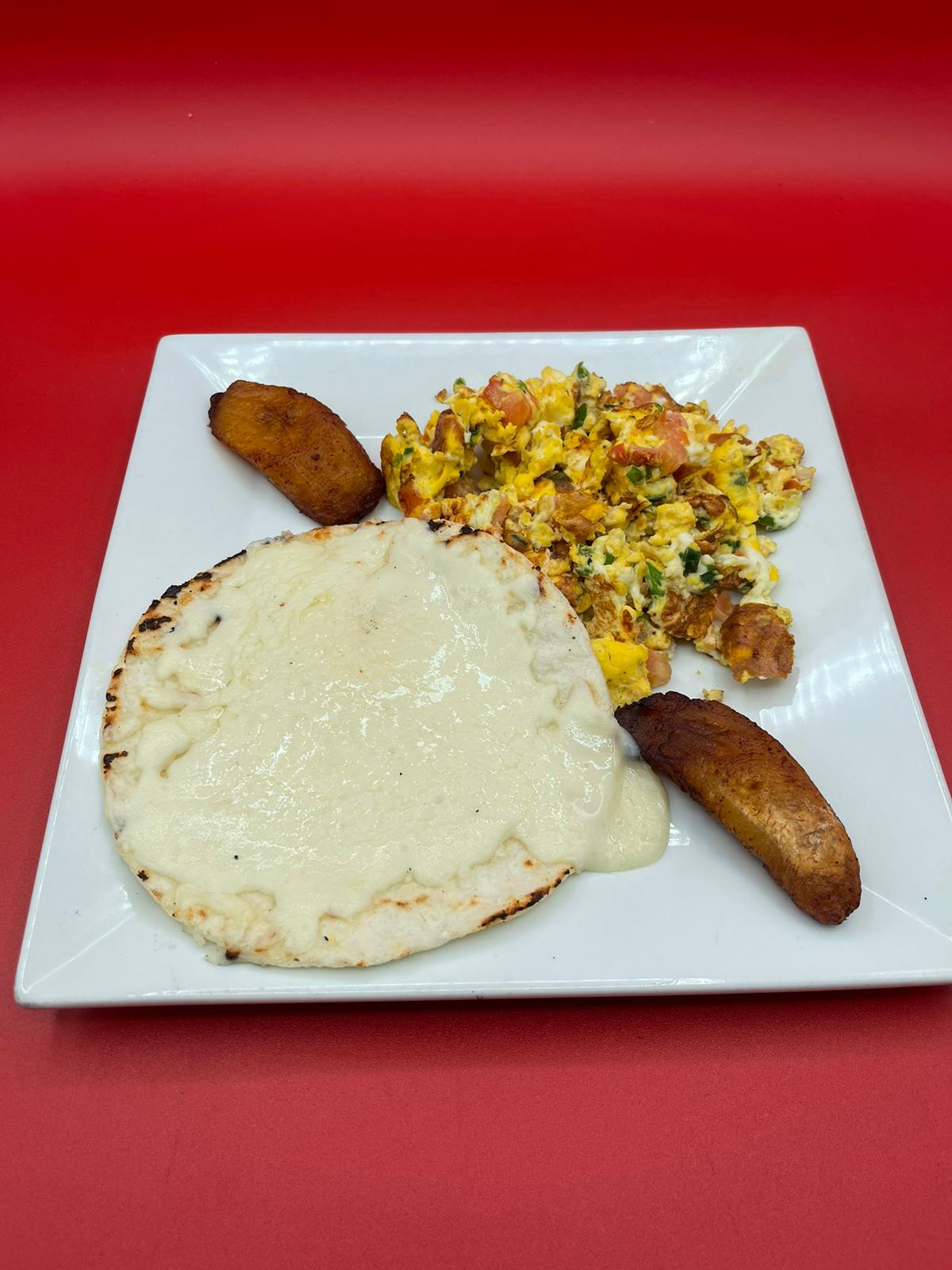 A plate with eggs, potatoes, and bread on a red background.