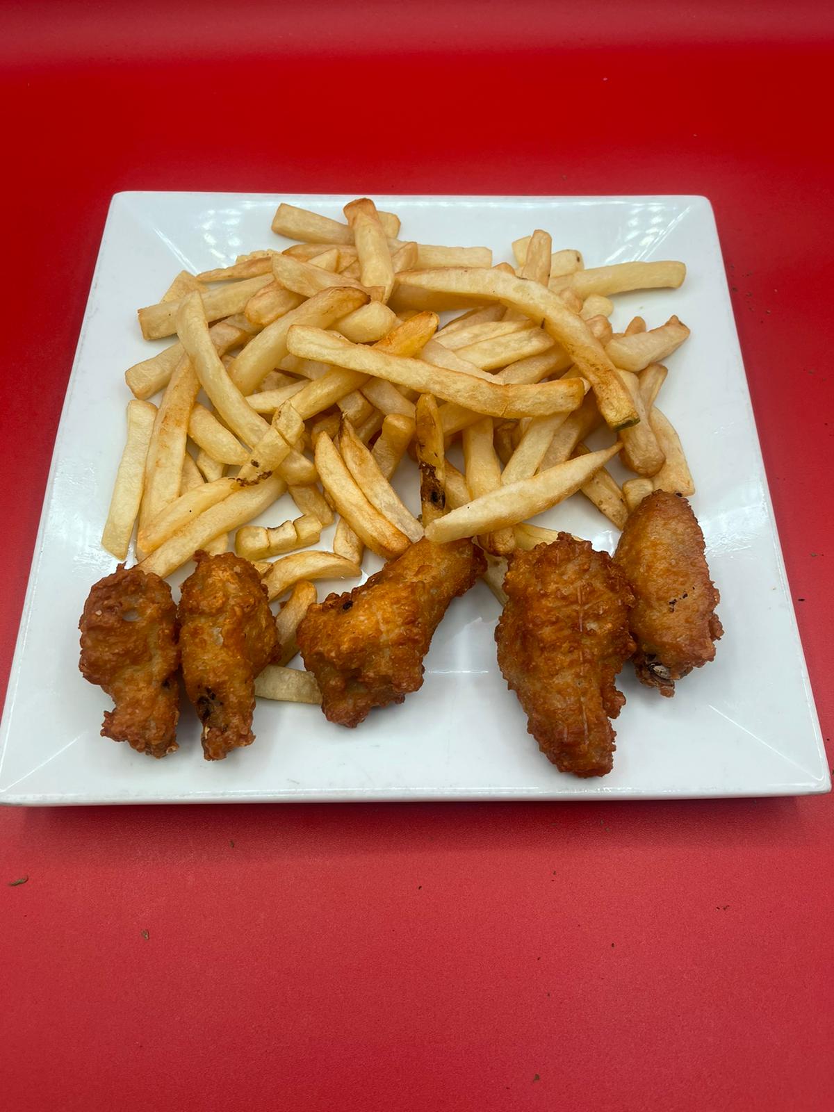 Chicken wings and french fries on a white plate.