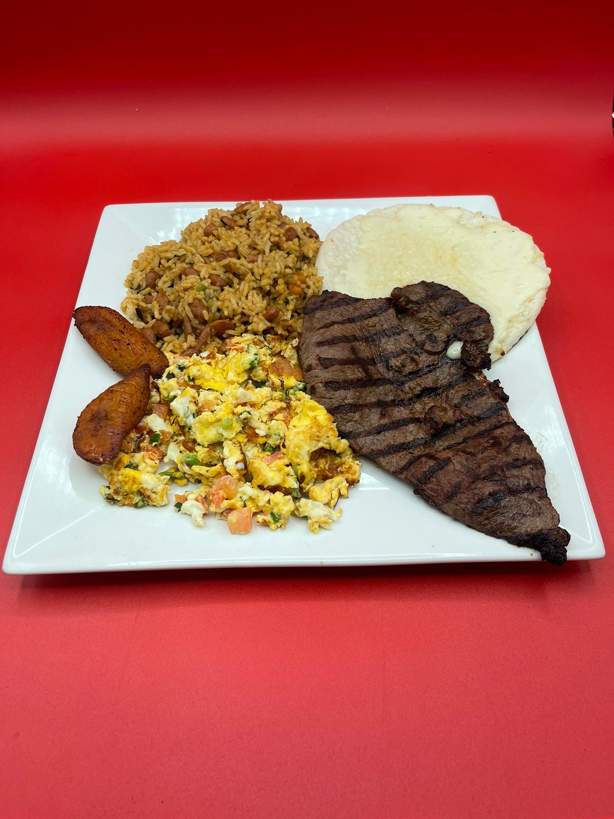 A plate with steak, rice and beans on it.