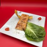A plate with salmon and lettuce on it.