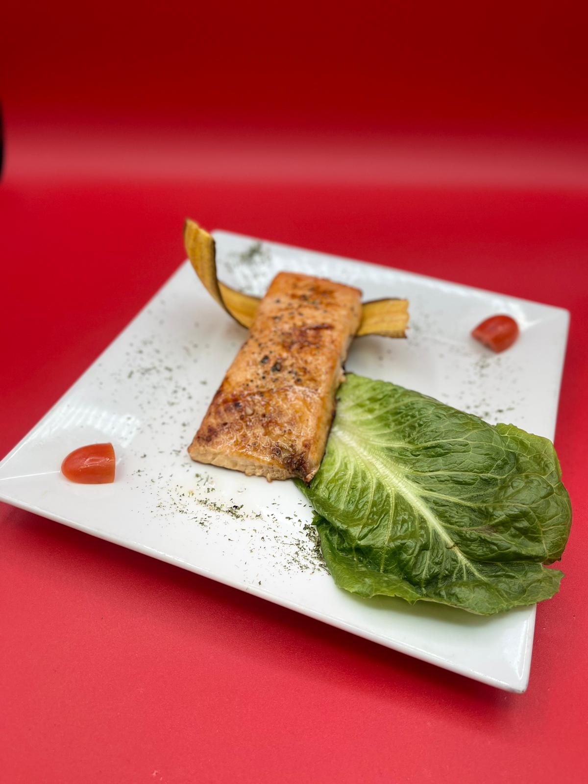 A plate with salmon and lettuce on it.