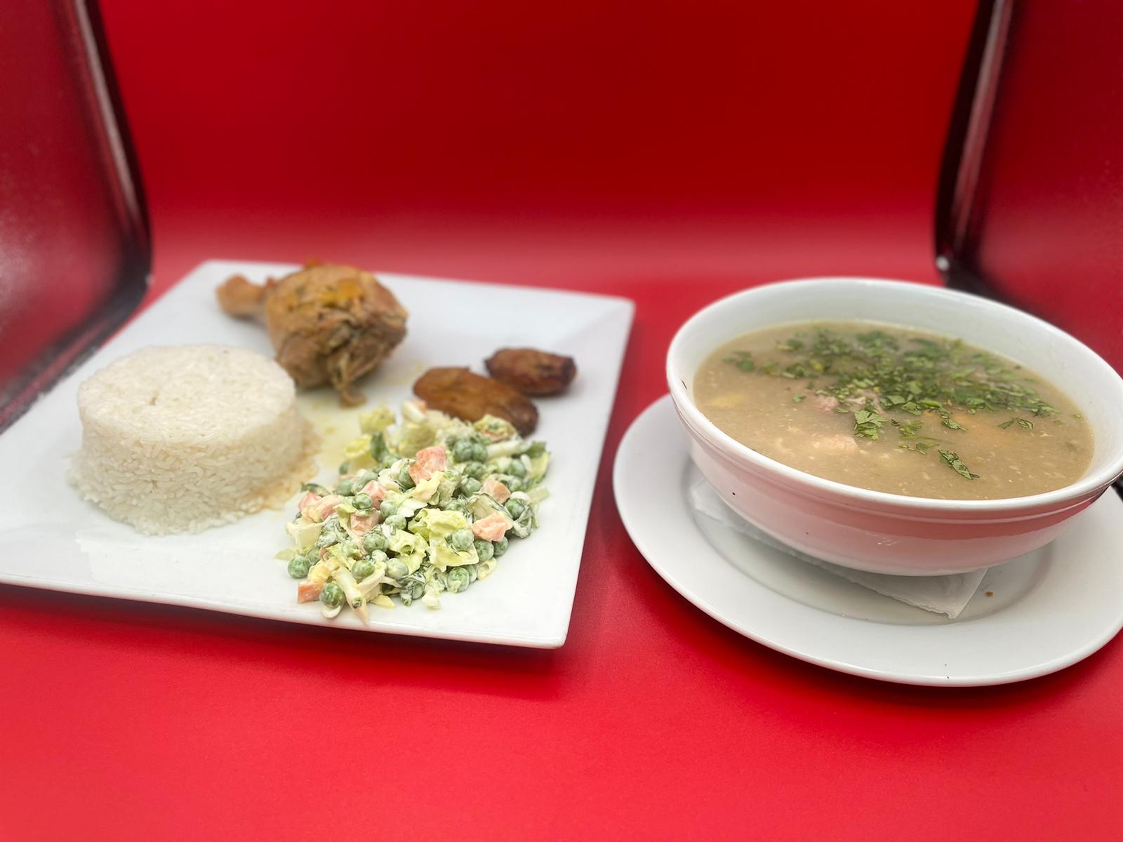 A bowl of soup and rice on a red plate.