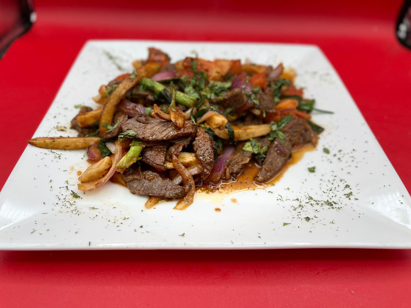 A plate of beef and vegetables on a red plate.