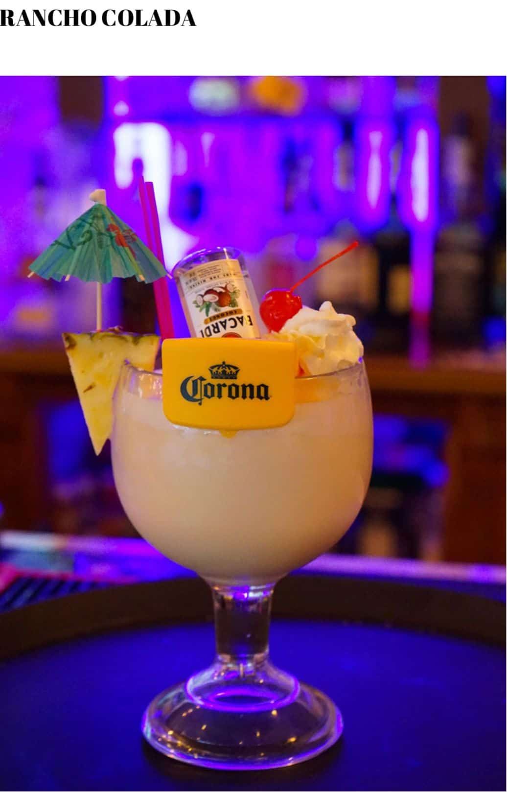 A drink with a pineapple on top of it is sitting on a bar.