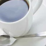 A cup of coffee with a spoon on a saucer.